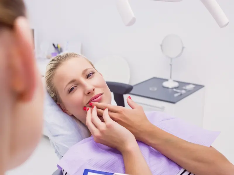 Dentista examinando a una paciente durante una consulta dental de emergencia en Fresno, CA